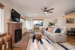 The living room features ample seating and a cozy fireplace. 