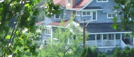 Large shady front porch seen through the trees