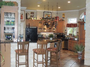 Bar area between kitchen and dining has 3 bar stools