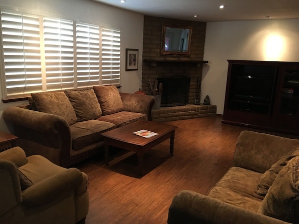 Living room with wood burning fireplace and cable TV.