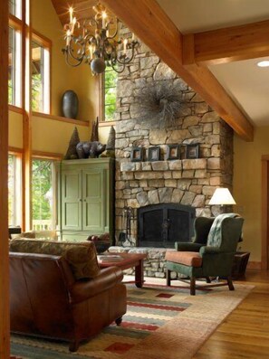 The cozy great room is hightlighted by a beaut. stone fire place and great views