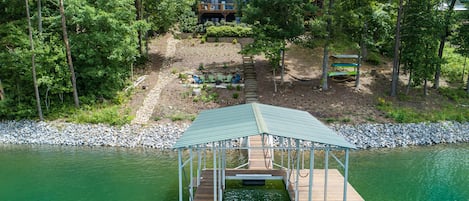 View from the water of our dock, firepit, hammocks, kayak rack and the house