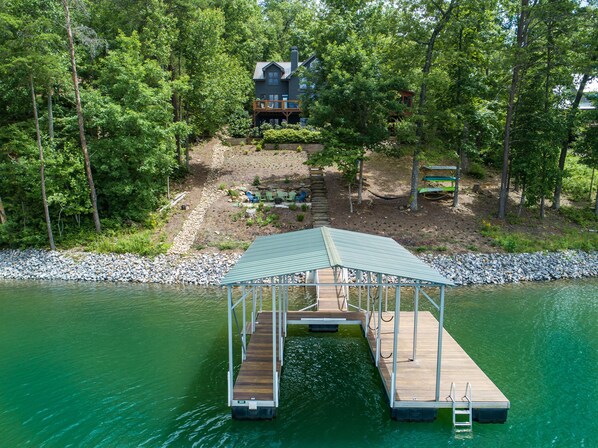 View from the water of our dock, firepit, hammocks, kayak rack and the house