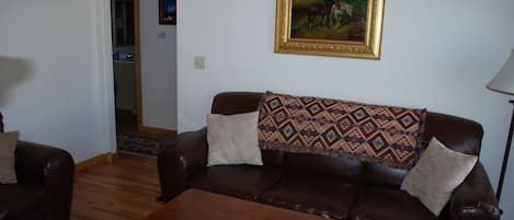 Cozy living room has a sofa & loveseat. Cable TV and a DVD player are provided.