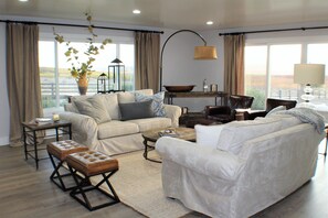 Plenty of seating in living room with fire place and 60 inch television 