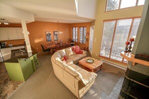 Vast kitchen/dining/living area with a cathedral ceiling and fireplace