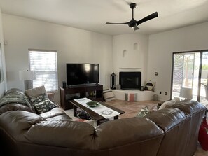 Large couch with cozy gas fireplace and 60” tv