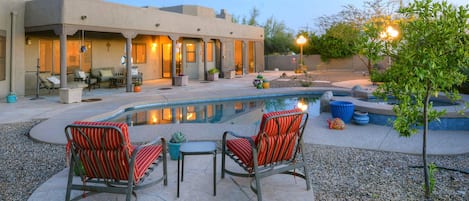 Evening view of backyard pool and hot tub. 