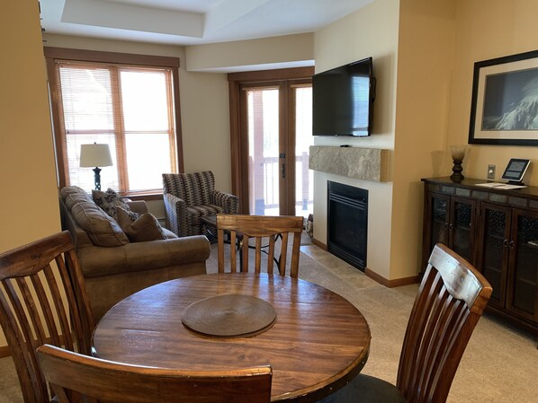 Dining and living areas with gas fireplace and flat screen TV