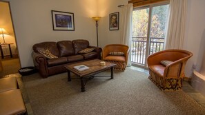 Lounge area with flatscreen TV and sleeper sofa plus 2 bar stools
