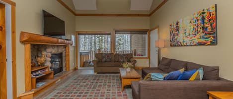 KR411 living room with two pull-out sofas. Leads to back deck with over-sized hot tub and patio furniture. 