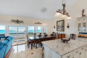 View from kitchen, showing ocean through 5 (of 10) floor-to-ceiling windows.