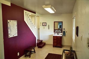 Towels and beach toys stored in the foyer. Stairs lead up to main living space. 