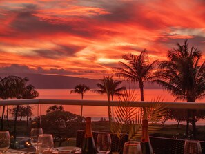 Immerse yourself in paradise with a vibrant, palm-lined sunset view from your lanai, offering a serene and picturesque dining atmosphere.