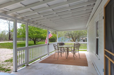 The front porch welcomes you with a table and 4 chairs.