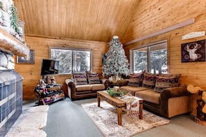 The living room has high vaulted ceilings and a real wood-burning fireplace It is one of our most popular cabins!