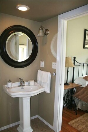 The master bathroom has a pedestal sink and bathtub/shower.