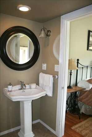 The master bathroom has a pedestal sink and bathtub/shower.