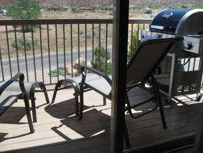 Nice patio with 2 chairs, grill and great place to store bikes