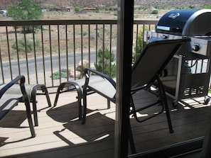 Nice patio with 2 chairs, grill and great place to store bikes