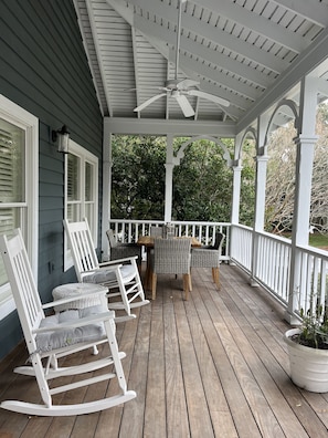 The other half of front porch w/ table for meals, and more rocking chairs.