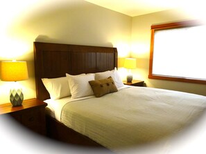 Master bedroom on main floor with a king sized bed. Mountain view in the window.