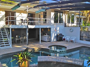 The pool areas and BBQ grill from the raised sun bathing landing.