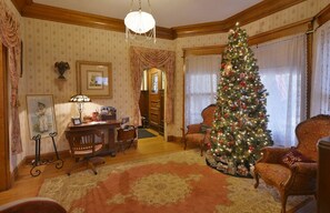 A Victorian Christmas. A room full friends and family gathered around the tree.