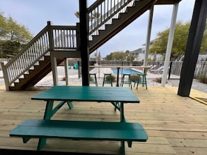 ground level deck with bar and picnic table near pool