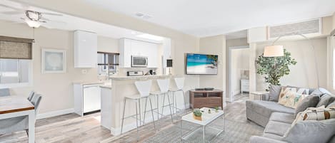 Bright and cheery, this spot is a guest favorite! The living room includes a sectional sofa, cable TV, and barstool seating for 3 at the adjacent kitchen counter.