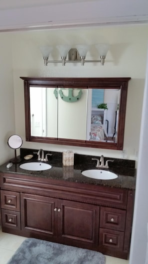 Double vanity separated by pocket door from toilet & bathtub / shower