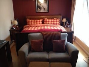 Master Bedroom with Couch and desk to the right. Air conditioning in window