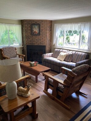 Another view of Living Room w/ a wood burning fireplace and plenty of seating