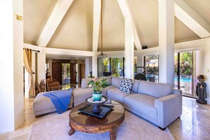 Inside the living room with a view of the outdoor patio which has the pool