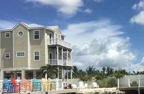 View of  back of house which overlooks the beach, dock, pool, and Cudjoe Bay.