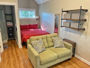 Open living with queen bed and love seat 