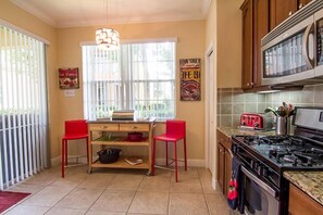 Spacious kitchen with extra seating, pantry, oven, microwave and Lanai to left