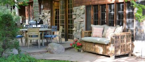 Side patio with heating lamps and gas grill, overlooking garden lot.