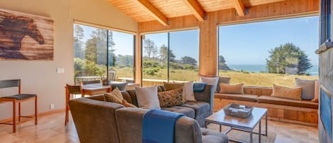 The great room with panoramic views to the meadows and sea