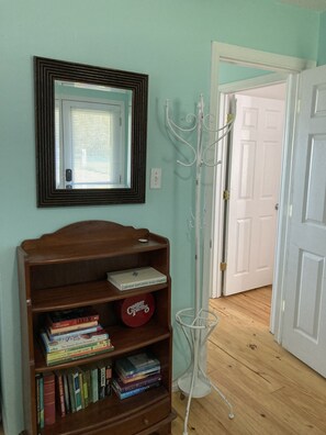 Bookcase and coat rack in entry area with door to mail living area