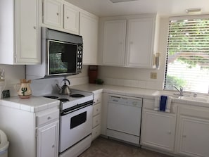 Sunny kitchen provides all amenities with pass through  window to patio dining
