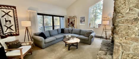 Living room, wood burning fireplace, open concept, high ceilings, natural light