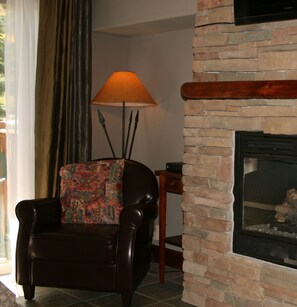 Stone floor to ceiling fireplace, leather armchair
