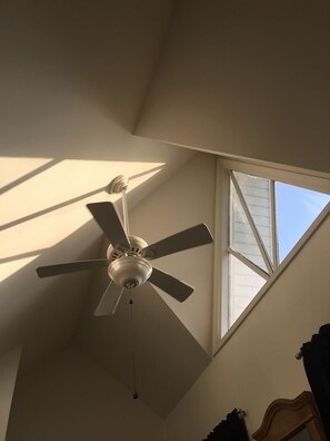 Master bedroom with cathedral ceiling and fan.