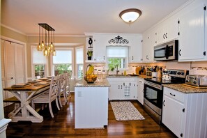 The updated eat in kitchen w/granite counters and a plethora of kitchen wares.