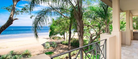 Daytime view from the large private balcony of the beach trail, sand and water.