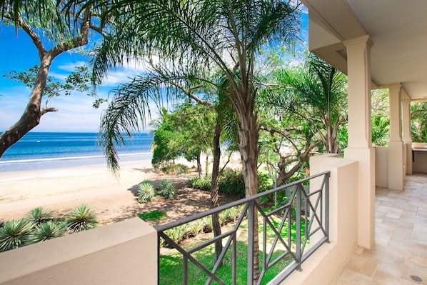 Daytime view from the large private balcony of the beach trail, sand and water.