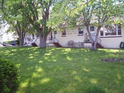 Newly landscaped large yard with shade trees, hammock, BBQs and patio furniture