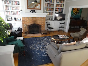 Living room with wood burning fireplace and lots of books to explore