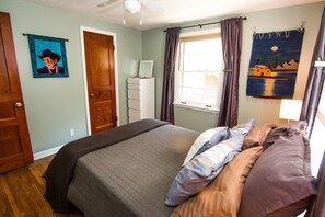 Bedroom with queen sized bed, closet and dressers, handmade quilt art of Willie